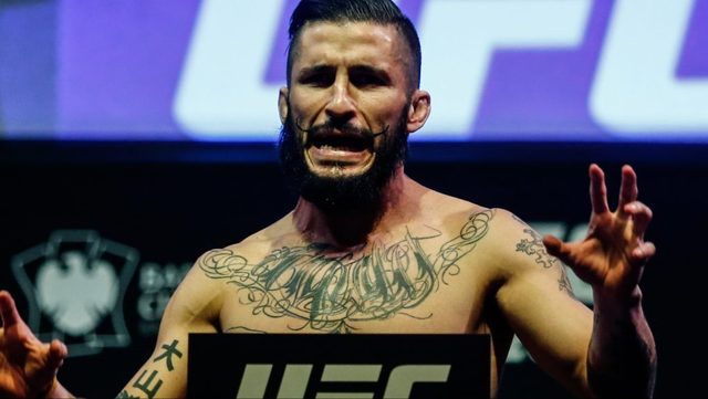 Ian McCall poses on the scale at the UFC 208 ceremonial weigh-in